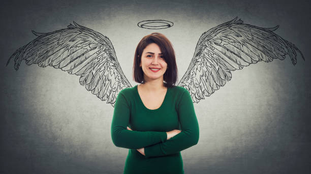 Positive confident woman arms crossed smiling broadly imagining herself an angel with fluffy wings behind her back and a halo above head. Super power idea, self development concept inner strength.