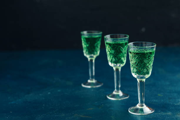 Traditional italian or czech liqueur or bitter with fennel. Three absinthe glass Traditional italian or czech liqueur or bitter with fennel. Three absinthe glass. Dark blue concrete table surface background, copy space for you text. absinthe spoon stock pictures, royalty-free photos & images