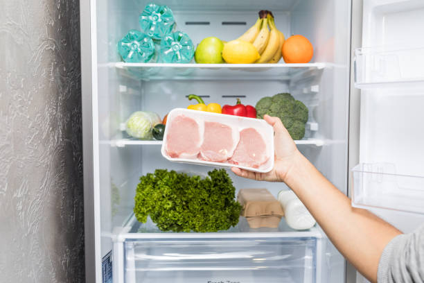 istock Hands take meat standing next to the open fridge. Food. 1132821108