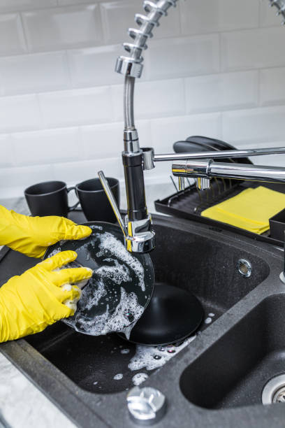 istock Male hands cleaning dish, plate with modern tap at kitchen 1132821319