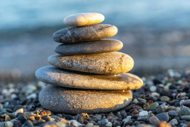 istock Stones pyramid on pebble beach symbolizing stability, zen, harmony, balance. Shallow depth of field. 1132821483