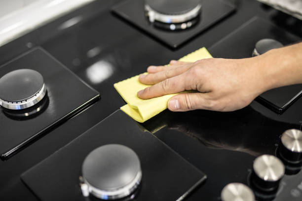 istock Young man hands in rubber protective cleaning and polish cooker. Black shiny surface of kitchen top, hands, detergent. Set cleaning concept 1132822971