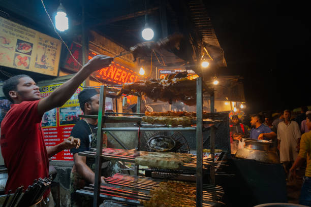 Chicken seekh kababs are being prepared road side OLD MARKET, NEW DELHI, INDIA - OCTOBER 28 2018 : Spicy chicken seekh kababs are being prepared by men and being stacked on the road side for sale as street food. It is famous for various street foods. old delhi stock pictures, royalty-free photos & images