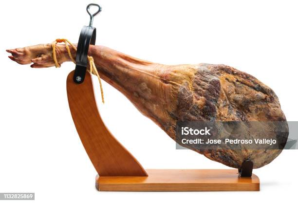 Whole Leg Of Spanish Iberian Serrano Ham In Wooden Support Isolated On White Background Stock Photo - Download Image Now