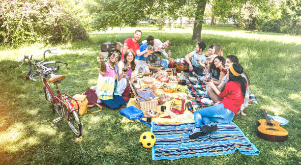 happy friends group having fun outdoor cheering at bbq picnic with snacks food drinking red wine - young people enjoying spring time together at barbecue garden party - youth milennials concept - picnic family barbecue social gathering imagens e fotografias de stock