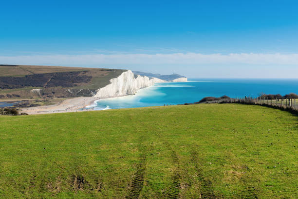 Cuckmere Haven, Seaford, England Walk to Cuckmere Haven beach near Seaford, East Sussex, England. South Downs National park. View of blue sea, cliffs, beach, selective focus east sussex stock pictures, royalty-free photos & images