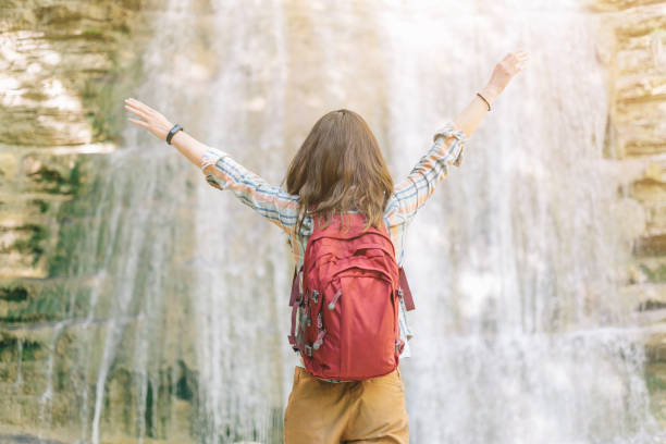 istock Happy explorer girl near the waterfall. 1132832469
