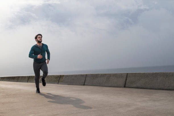 istock Active Young Man Jogging on A Foggy Winter Morning 1132833953