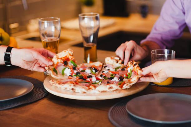 amigos comiendo pizza en la mesa - gourmet enjoyment food freshness fotografías e imágenes de stock