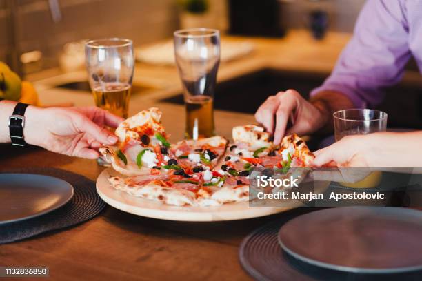 Photo libre de droit de Amis Mangeant La Pizza À La Table banque d'images et plus d'images libres de droit de Pizza - Pizza, Bière, Manger