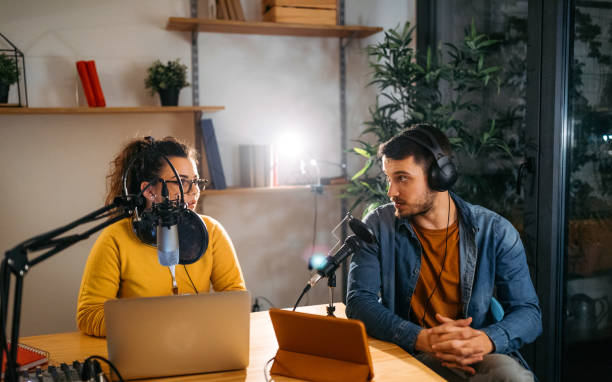 She is expert in radio interviews Photo of two young people recording a podcast in a studio commentator photos stock pictures, royalty-free photos & images