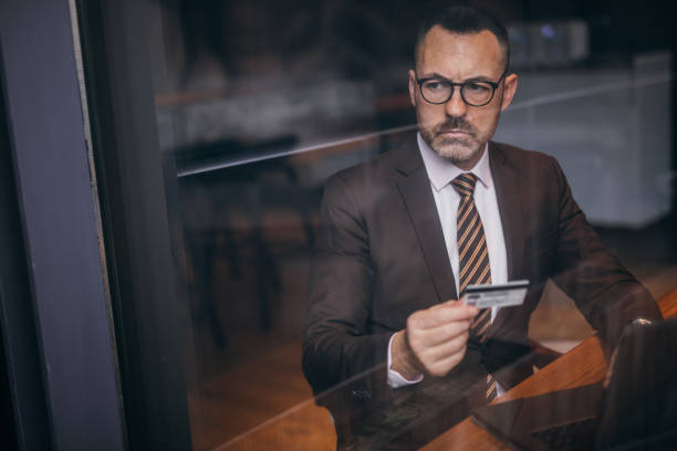 istock Serious senior businessman is using credit card 1132839857