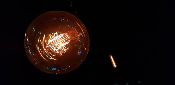 istock close up of yellow electric light bulb in dark environment 1132841128