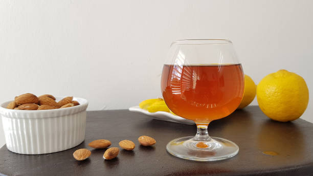 istock glass half full with brandy on brown table near roasted almonds and fresh lemons 1132841585