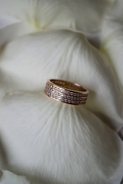 istock Wedding ring on white petals of roses. 1132842719