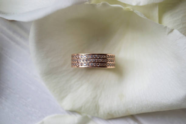 istock Wedding ring on white petals of roses. 1132842827
