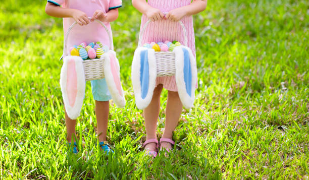 イースターエッグハントの卵バスケットを持つ子供たち。 - bunny painting ストックフォトと画像