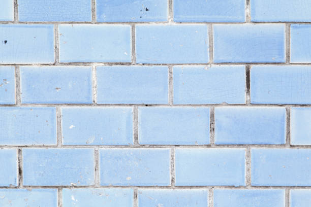 Four horizontal rows of old rectangular ceramic tiles of a sky blue color covered with many small surface crack