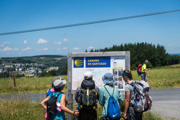 pellegrini che guardano la mappa del camino de santiago - portomarin foto e immagini stock