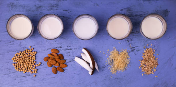 types of vegetable and organic milk in glass beakers types of vegetable milk, organic, in glasses on the blue stone table. view from above bicchiere stock pictures, royalty-free photos & images