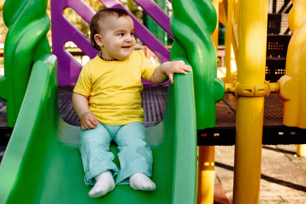 istock Cute boy happily playing on a playground slide 1132847868