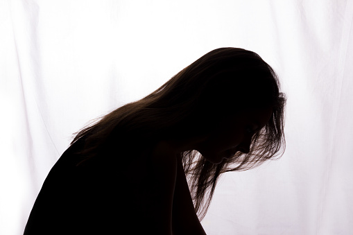 Silhouette of a young woman with problems - horizontal