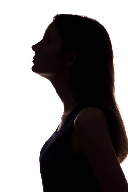 istock Young woman looking up - vertical silhouette 1132849740