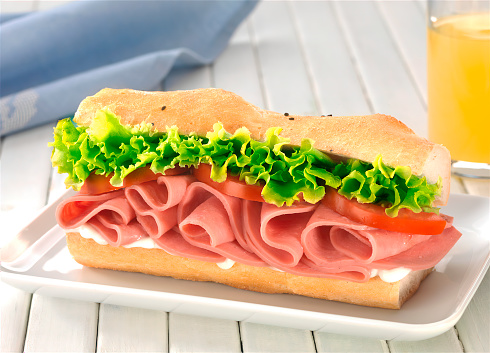 Sandwich with tomato, cheese, ham and fresh lemon juice