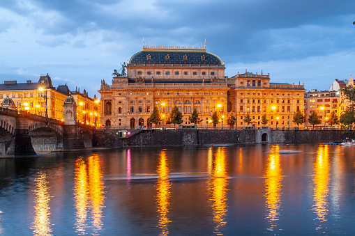 Prague National Theatre by night. Illuminated embankment and Vltava River. Prague, Czech Republic