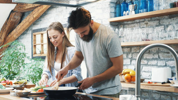 istock Young couple making dinner together at home 1132874137
