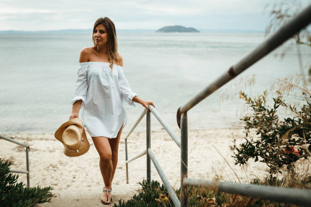 istock Casual dressed woman with a sun hat going to the beach 1132879177
