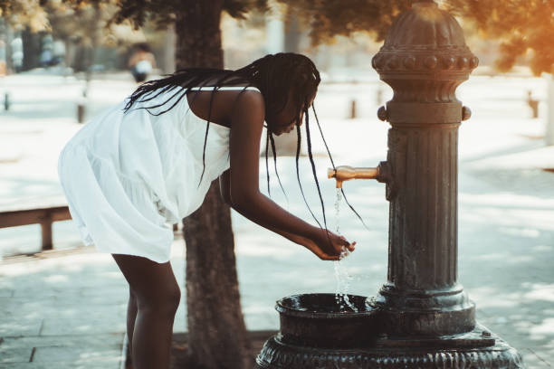 Black girl is using street washbasin