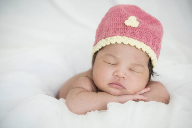 istock newborn baby sleep in bed on white background 1132888572