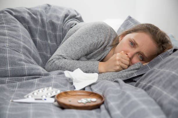 istock Sick young woman lying in bed, coughing 1132888746
