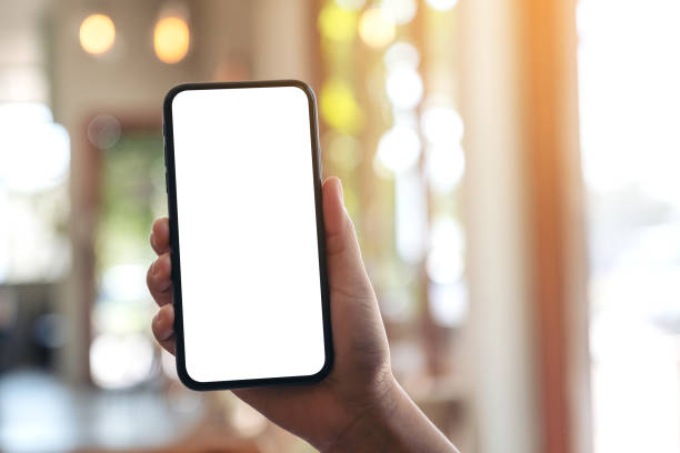 istock a hand holding and showing black mobile phone with blank white screen 1132889562