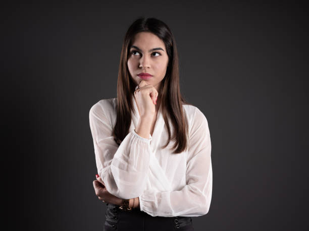 istock Young woman thinking on gray background 1132890568