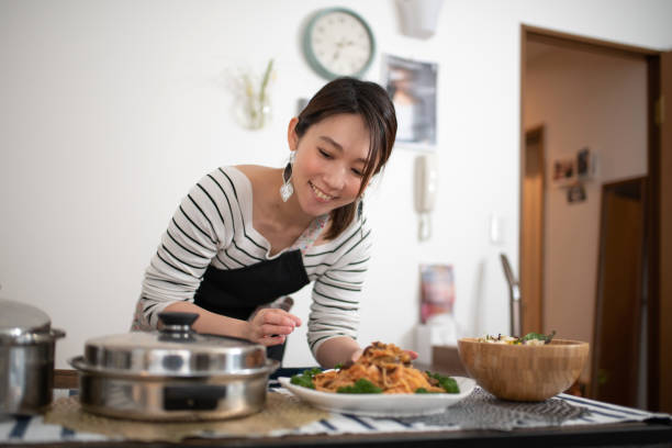 自宅で食事の準備をする女性 - 盛り付け ストックフォトと画像