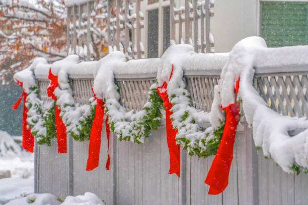 istock Fence with snowy garland and red bows in Daybreak 1132892734