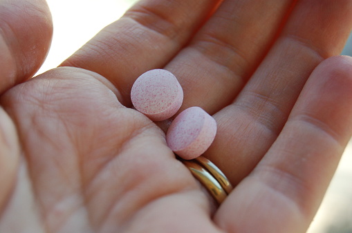 Vitamin pills in the palm of a female adult hand