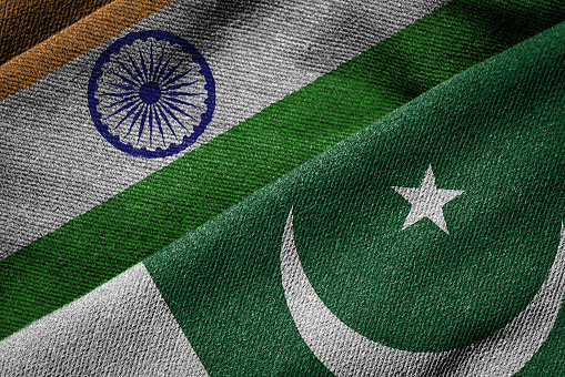 Overlapping grunge flags of India and Pakistan,  highlighting the ongoing political tension and conflict between the two neighboring countries since 1947.