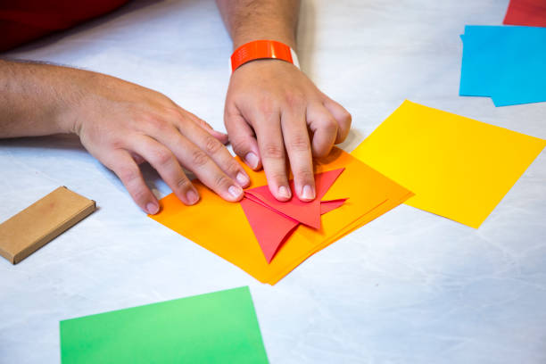 un hombre plegado de papel de origami - origami fotografías e imágenes de stock