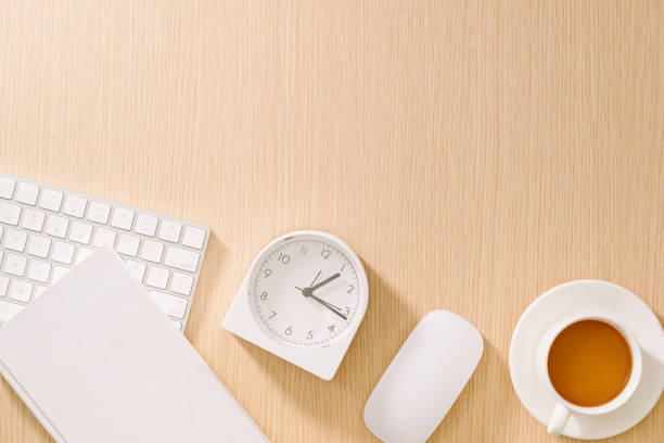 istock Modern white office desk with keyboard, mouse, notebook, clock and cup of coffee. Top view with copy paste. Business and strategy concept mockup. 1132900378