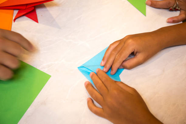 istock Child folding origami paper 1132900977