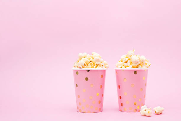 istock two cups of popcorn on a pink background 1132915500