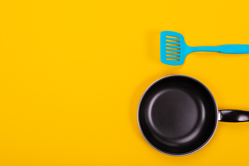 Kitchen utensils isolated on yellow background