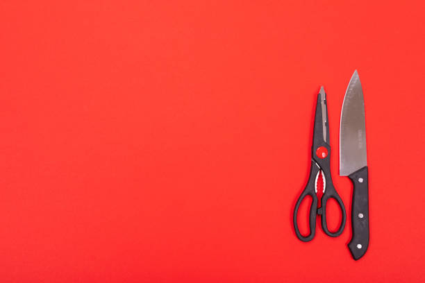 istock Knife and scissors are isolated on a red background 1132918116
