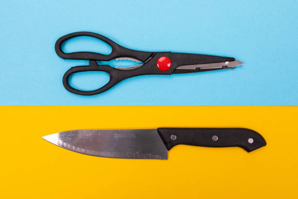 istock Scissors and knife isolated on yellow-blue background 1132918136