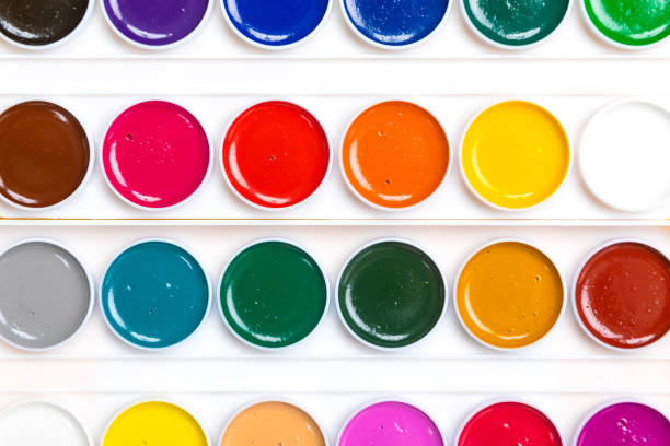 istock palette with paints close-up lie isolated on yellow background 1132918276