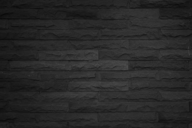 istock Seamless Black pattern of decorative brick sandstone wall surface with concrete of modern style design decorative uneven have cracked realmasonry wall of multicolored stones or blocks white cement. 1132919350