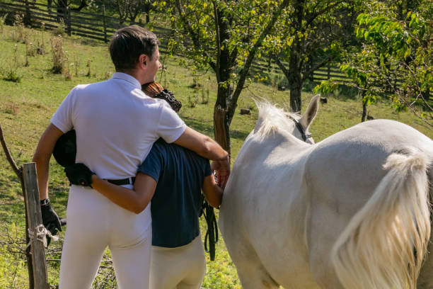 istock Colleagues horseback riders hugging, rear view 1132922834